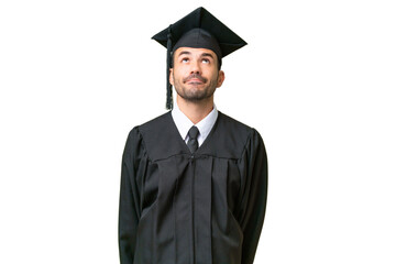 Young university graduate man over isolated background and looking up