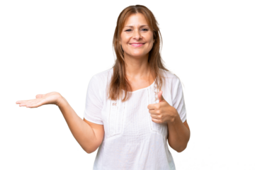 Middle-aged caucasian woman over isolated background holding copyspace imaginary on the palm to insert an ad and with thumbs up