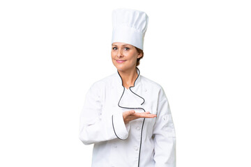 Middle-aged chef woman over isolated background presenting an idea while looking smiling towards