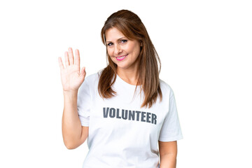 Middle age volunteer woman over isolated background saluting with hand with happy expression