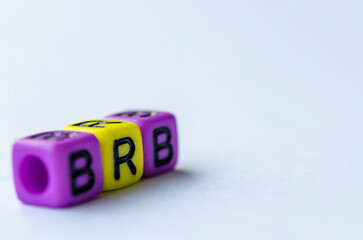 BRB text representing Be Right Back on small square toy on white background. Break time concept