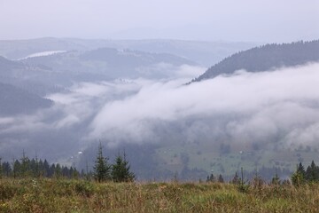 Picturesque view of beautiful mountains covered with fog