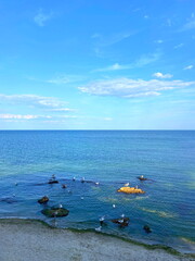 An amazing panorama of the sea horizon connecting the azure water surface with the blue sky illuminated by the setting sun.