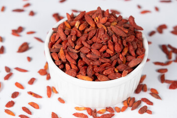 Dried Goji berries in a plate on a white background