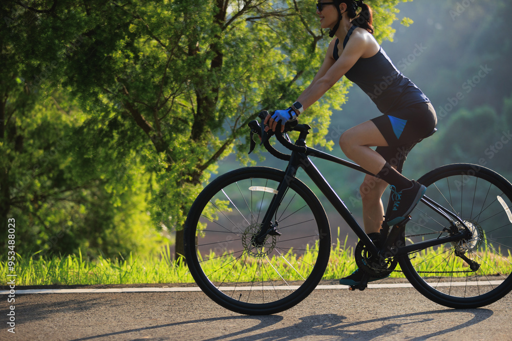 Wall mural Woman cyclist riding bike in summer park