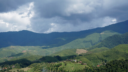 Fototapeta premium The perspective of the mountain range with nimbus clouds in the sky