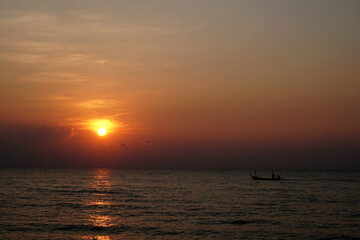 The perspective of the fishing boat in the sea with a sunrise background