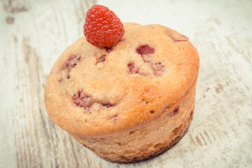 Fresh baked muffin with raspberries and chocolate. Delicious dessert