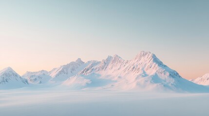 A snow-covered mountain range at dawn with a clear sky