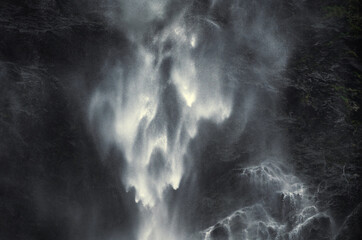 Part of a magnificent large waterfall as a dreamy, almost abstract high contrast image. White water on dark cliffs. 