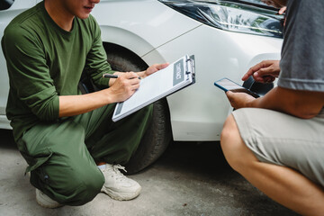 Three Asian men discussing car insurance policies with adjuster. They review details such as...
