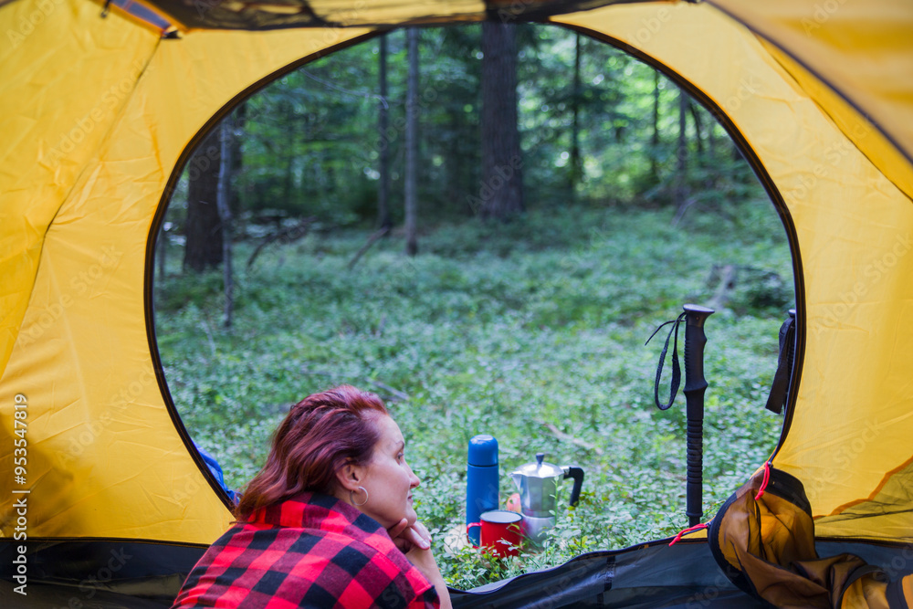 Wall mural camping on a clearing in the middle of the forest. a young girl is resting in a tent.