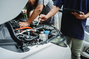 Three Asian men discussing car insurance policies with adjuster. They review details such as premiums, deductibles, coverage options while handling recent claim and evaluating the settlement process.