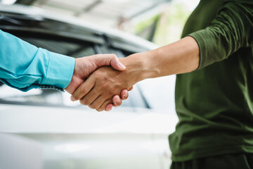 Car seller agent signs a car insurance agreement with salesman. The document outlines vehicle policy, premium, rental terms, with contract paper finalized using car insurance claim mobile phone.