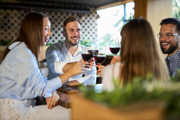 Group of happy business colleagues toasting with wine in a restaurant