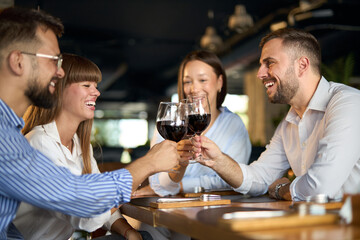Group of happy business colleagues toasting with wine in a restaurant