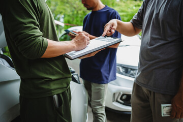 Three Asian men discussing car insurance policies with adjuster. They review details such as premiums, deductibles, coverage options while handling recent claim and evaluating the settlement process.