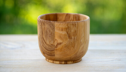 Handcrafted wooden cup. Empty cup for drink. Mock-up. Close-up. Natural green backdrop.