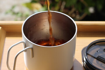 Pouring tea in cup. Healthy hot drink. Black tea drink. Cup Of Tea Closeup Over Nature Green Background