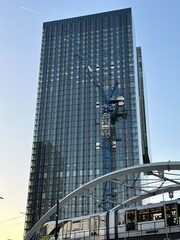 Looking up at modern buildings with construction cranes and a sky background. Taken in Manchester England. 