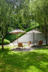 Table, chair and umbrella in green garden