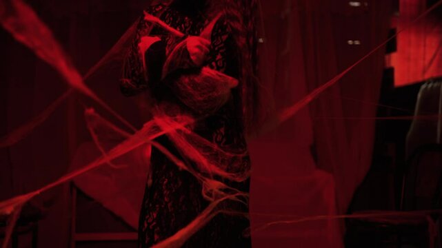 fantasy woman witch wearing black dress in dark room full smoke covering cobweb. Girl in gothic room with candles at night
