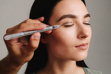 Surgeon is planning process of upper blepharoplasty with marker. Surgeon is drawing marking lines...