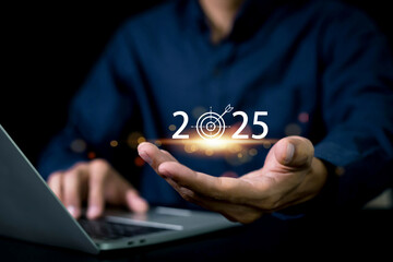 Set goals for 2025. Businessman holds 2025 text with business operations goals. To achieve the goals of a growing business