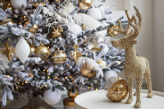 A beautifully decorated Christmas tree. Nearby is a table with festive New Year toys and decorations.
