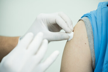 Close up doctor holding syringe make injection to patient in medical mask.Covid-19 or coronavirus vaccine.Vaccine for protection HPV (Human Papillomavirus) infection