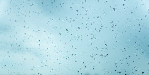 Close-up of water drops on glass in rainy season. Panoramic banner Pattern or Background.
