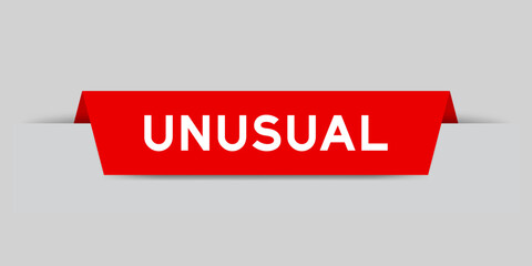 Red color inserted label with word unusual on gray background
