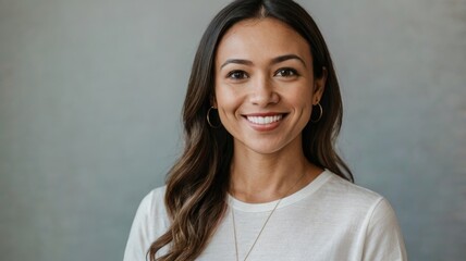 Young woman smiling wearing white t-shirt on grey background