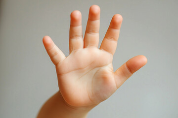 child's open hand showing palm against neutral background, closeup view