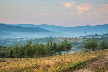 A Serene and Beautiful Landscape Featuring Majestic Mountains and a Misty Horizon Above