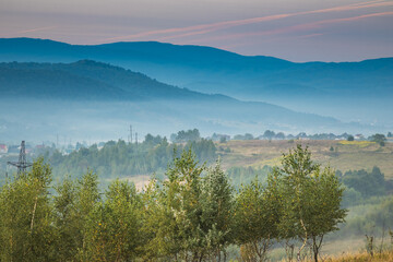 A Serene and Beautiful Landscape Featuring Majestic Mountains and a Misty Horizon Above