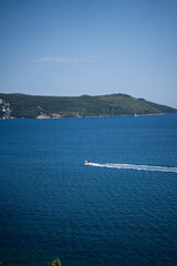 Small boat in the sea against the background of mountains.
