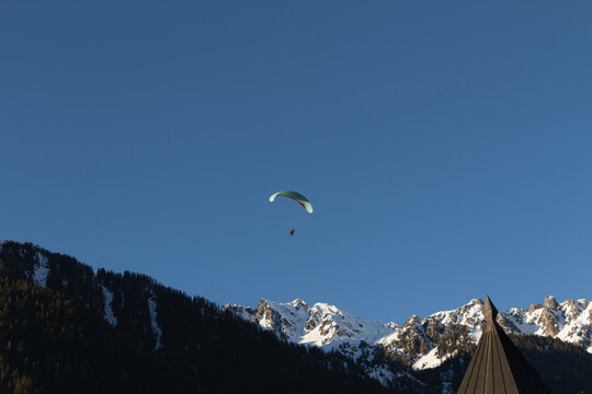 Paraplan and deltaplan in alps over a ski resort