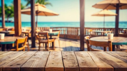 Empty wooden tabletop with blurred tropical beachfront cafe in background