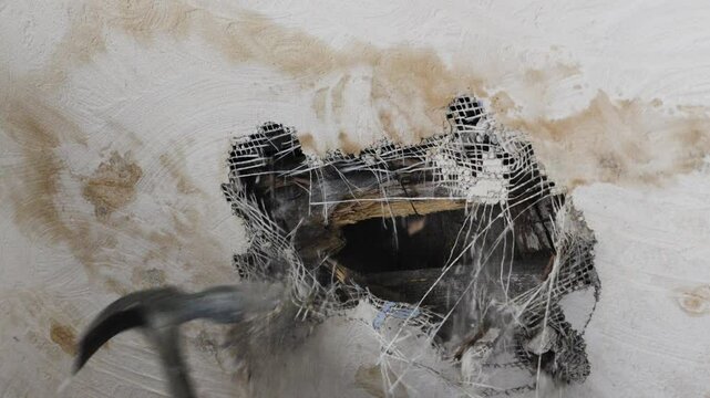 smashing a wall with a hammer 