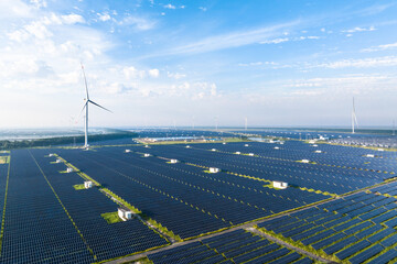 view of solar power station and wind turbine in field