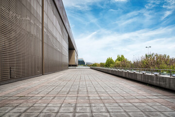 Obraz premium Long Paved Walkway Beside a Modern Perforated Facade