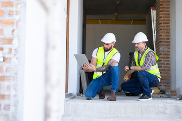 Architect and contractor working on building in construction site. Two Professional Architects Engineer Working on Personal laptop computer at house construction site