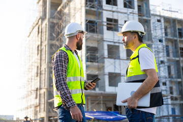 Architect and contractor working on building in construction site. Two Professional Architects Engineer Working on Personal laptop computer at house construction site