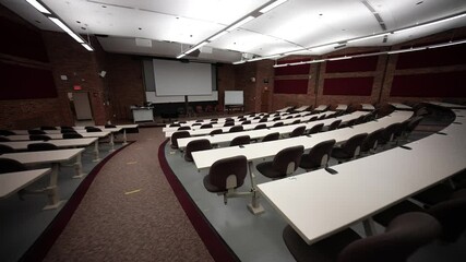 Empty university or college presentation lecture hall with rows of seats for students and speaker. No people.