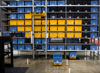 Autonomous robot picking materials from multi-layer rack in modern industrial warehouse.