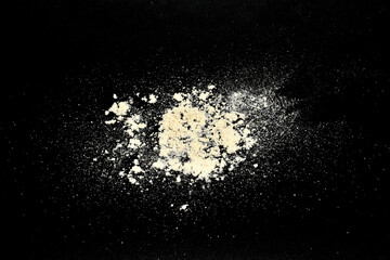 Ordinary yellow construction sand is scattered on a black background.