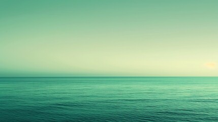Fototapeta premium A minimalist background featuring a gradient of green shades, evoking a calm ocean or sky.