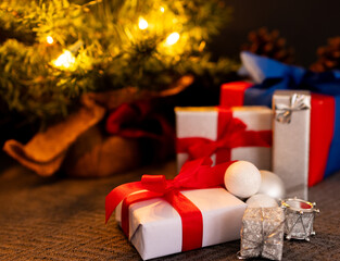 Handmade Christmas gift boxes with illuminated Christmas tree in the background