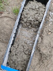 A concrete block with a wire mesh in it is filled with concrete